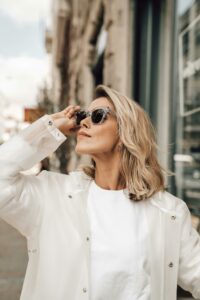 Femme blonde avec des lunettes de soleil regardant vers le haut
