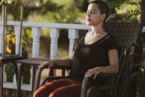 Une femme assise dans un fauteuil, les yeux fermés vivant l'hypnose pour relation amoureuse