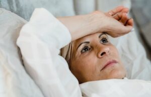 Femme allongée avec poignet sur le fond réfléchissant au prochain rendez-vous avec Marie-Christine Eustache